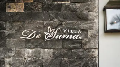 a sign on the side of a brick wall at Villa De Suma - Fully Staffed Luxury Villa, Central Seminyak, walk to the beach in Seminyak