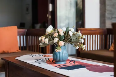 a blue vase filled with flowers on a table at Bali Radiance Villas Seminyak in Seminyak