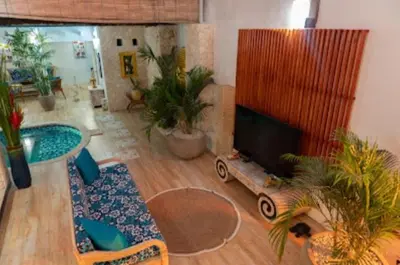 a living room with a flat screen tv and plants at Shray Villa. Legian in Legian