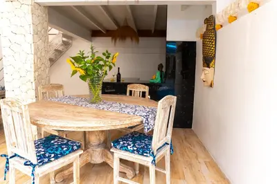 a dining room table with chairs and a vase on it at Shray Villa. Legian in Legian