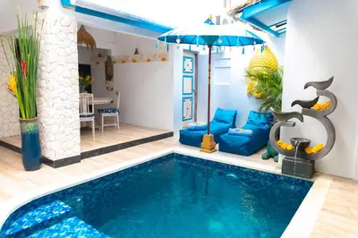a living room with a pool and an umbrella at Shray Villa. Legian in Legian