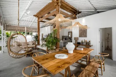 a dining room with a wooden table and chairs at Villa Cyma by Alfred in Bali in Seminyak
