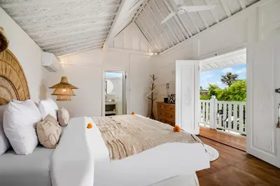 a white bedroom with a bed and a balcony at Villa Cyma by Alfred in Bali in Seminyak