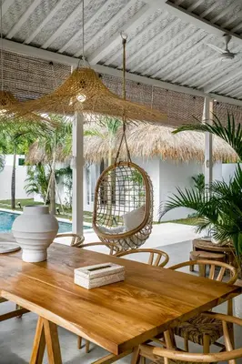 a dining room with a table and a hanging chair at Villa Cyma by Alfred in Bali in Seminyak