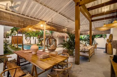 an open living room with a wooden table and chairs at Villa Cyma by Alfred in Bali in Seminyak