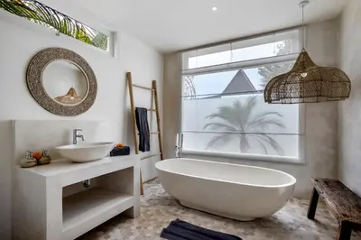 a bathroom with a tub and a sink and a window at Villa Cyma by Alfred in Bali in Seminyak