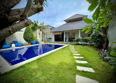 a backyard with a swimming pool and a house at Villa Majegau 1 Seminyak in Seminyak