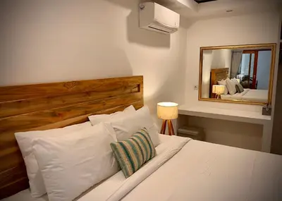 a bedroom with a white bed with a large mirror at Villa Majegau 1 Seminyak in Seminyak