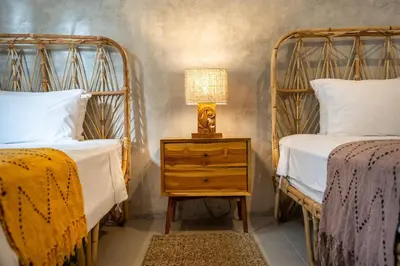 a bedroom with two beds and a lamp on a night stand at Little Boutique Hotel 106- 30m from beach in Canggu