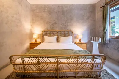 a bedroom with a bed and two lamps on tables at Little Boutique Hotel 102 - 30m from beach in Canggu