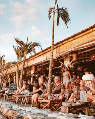 a group of people sitting outside of a restaurant at Little Boutique Hotel 102 - 30m from beach in Canggu