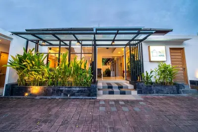 a house with a glass door and some plants at Little Boutique Hotel 102 - 30m from beach in Canggu