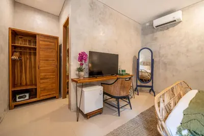 a bedroom with a desk with a computer and a bed at Little Boutique Hotel 103- 30m from beach in Canggu
