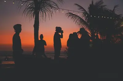 a silhouette of a wedding party on the beach at sunset at Little Boutique Hotel 107- 30m from beach in Canggu