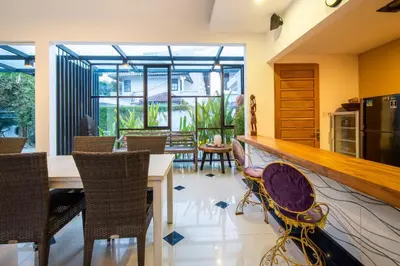 a kitchen and dining room with a counter and chairs at Little Boutique Hotel 108- 30m from beach in Canggu