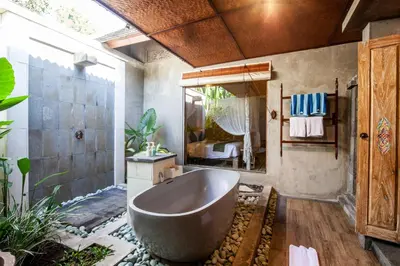 a bathroom with a large tub and a mirror at Sunset Paradise Villa Nusa Dua in Nusa Dua