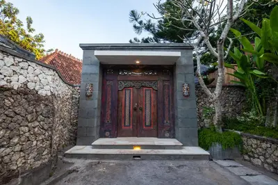 a wooden door with stairs in front of a building at Sunset Paradise Villa Nusa Dua in Nusa Dua