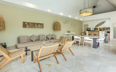 a living room with a couch and chairs and a table at Villa Gallici Seminyak in Seminyak
