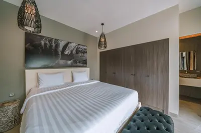 a bedroom with a large bed and a blue stool at Villa Batik - Brand New & Stylish 3BR Villa in Seminyak! in Seminyak