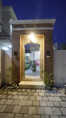 a mirror on the side of a building with plants at Maharani Residence in Denpasar