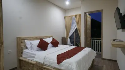 a bedroom with a large bed and a window at Maharani Residence in Denpasar