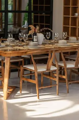a wooden table with chairs and wine glasses on it at Villa Kanopi Luxurious 3BR Villa with Pool and Quick Beach Access in Canggu