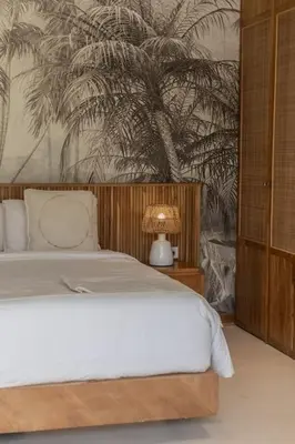 a bedroom with a bed and a palm tree mural at Villa Kanopi Luxurious 3BR Villa with Pool and Quick Beach Access in Canggu