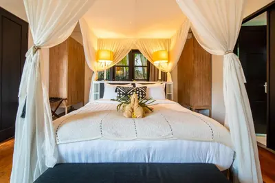 a bedroom with a bed with a teddy bear sitting on it at Lotus Luxury Villa Seminyak in Seminyak