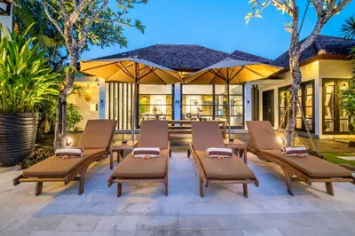 a group of chairs and tables on a patio at Lotus Luxury Villa Seminyak in Seminyak