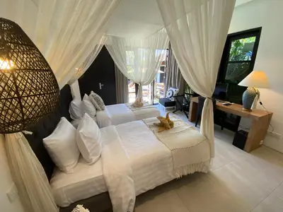 a bedroom with two beds and a large window at Lotus Luxury Villa Seminyak in Seminyak