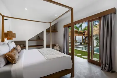 a bedroom with a canopy bed and a pool at Villa Mimpi Seminyak by Alfred in Bali in Seminyak