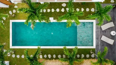 an overhead view of a swimming pool with palm trees at Villa Mimpi Seminyak by Alfred in Bali in Seminyak