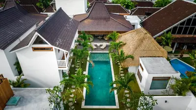 an aerial view of a villa with a swimming pool and palm trees at Villa Mimpi Seminyak by Alfred in Bali in Seminyak
