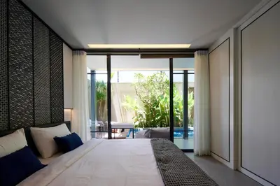 a bedroom with a large bed and a balcony at Adamare Villa Umalas in Kerobokan