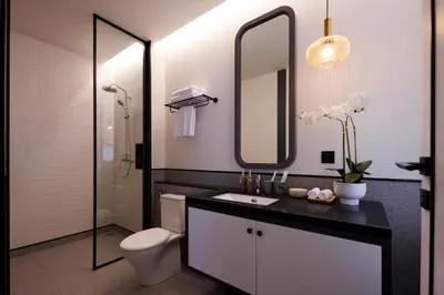 a bathroom with a toilet and a sink and a mirror at Adamare Villa Umalas in Kerobokan