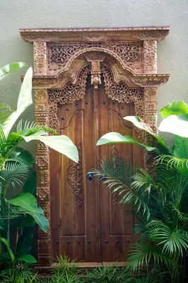 a wooden door in a building with some plants at Adamare Villa Umalas in Kerobokan