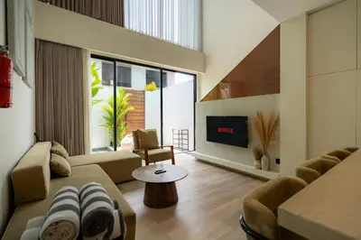 a living room with a couch and a tv at Oasis Villa 8 by Betterplace in Canggu