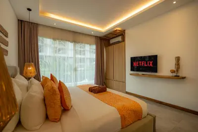 a bedroom with a large bed and a window at Flores Villa by Betterplace in Canggu