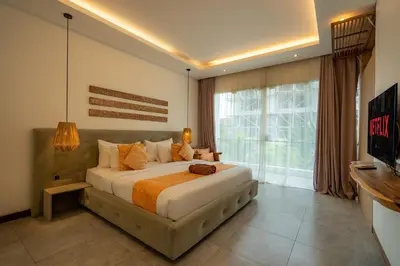 a bedroom with a large bed and a large window at Flores Villa by Betterplace in Canggu