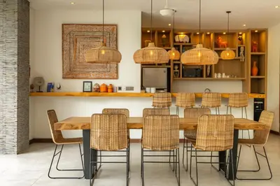 a kitchen with a wooden table and chairs at Flores Villa by Betterplace in Canggu