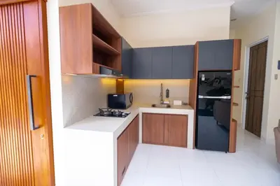 a kitchen with brown cabinets and a white counter top at Villa Kamandari in Kuta