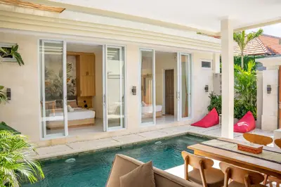 a villa with a swimming pool and a patio at Villa Kamandari in Kuta