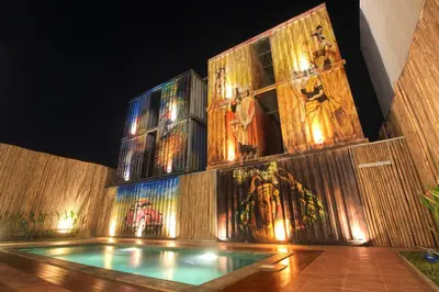 a church with a swimming pool in front of a wall with paintings at PAMELA BALI in Kerobokan