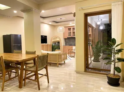 a dining room and living room with a wooden table at Cozy 3 Bedroom Villa in Seminyak in Seminyak