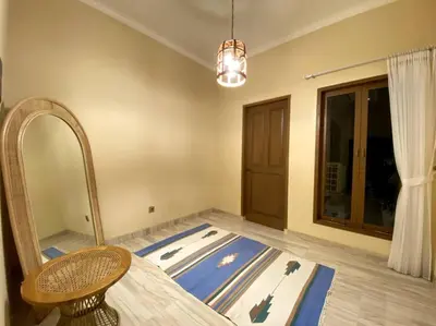 a room with a bed and a mirror and a table at Cozy 3 Bedroom Villa in Seminyak in Seminyak