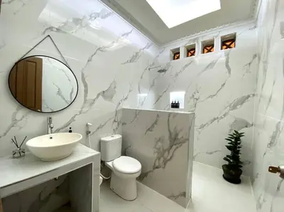 a bathroom with a sink and a toilet and a mirror at Cozy 3 Bedroom Villa in Seminyak in Seminyak