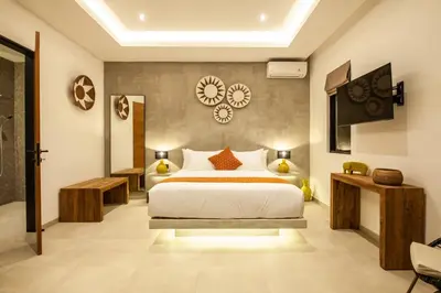 a hotel room with a bed and a tv at Zayana Villas Resort Seminyak in Seminyak