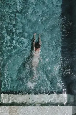 a person is swimming in a swimming pool at Designer 3BR Villa Tropical Stay Near Canggu in Kerobokan