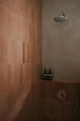 a bathroom with a shower with two bottles on a shelf at Designer 3BR Villa Tropical Stay Near Canggu in Kerobokan