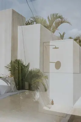 a white building with palm trees in the background at Designer 3BR Villa Tropical Stay Near Canggu in Kerobokan